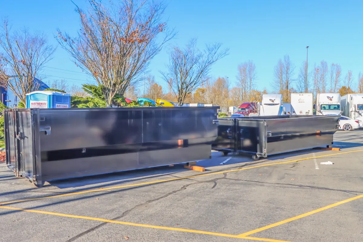 Professional dumpster rental service with roll-off container on residential driveway in West Deptford
